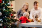 A family enjoying the holidays with a real tree, which you can keep from lighting on fire by keeping it well-watered.