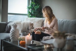 Woman using candles to reduce pet odors in her home